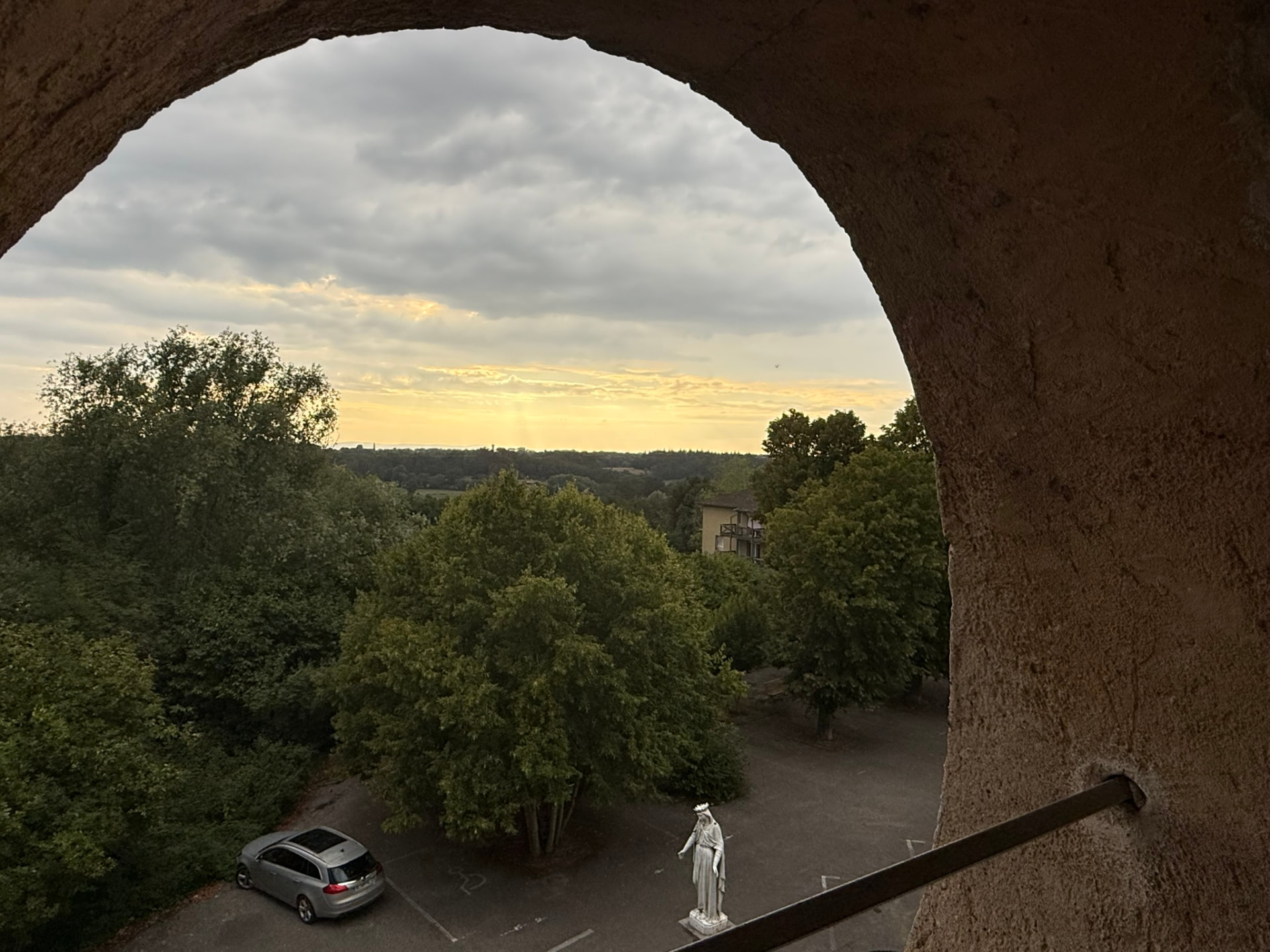 Vue sur les collines du Beaujolais au coucher du soleil depuis la fenêtre en plein cintre du salon