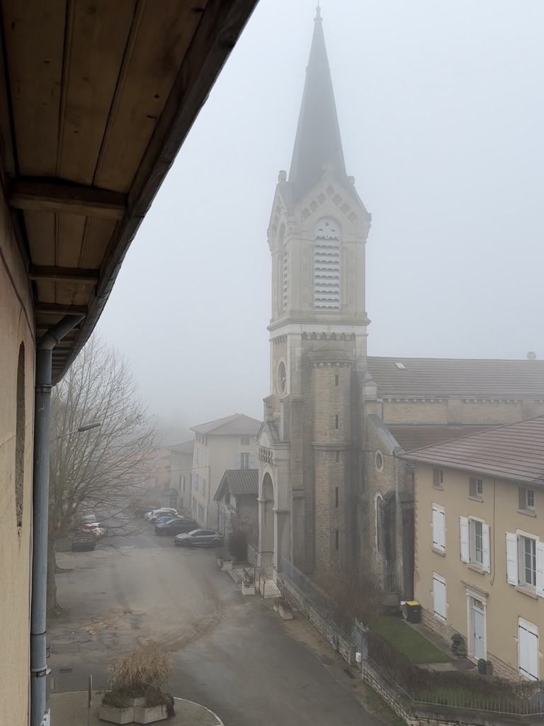Le clocher de l'église de Neuville-les-Dames dans la brume d'hiver