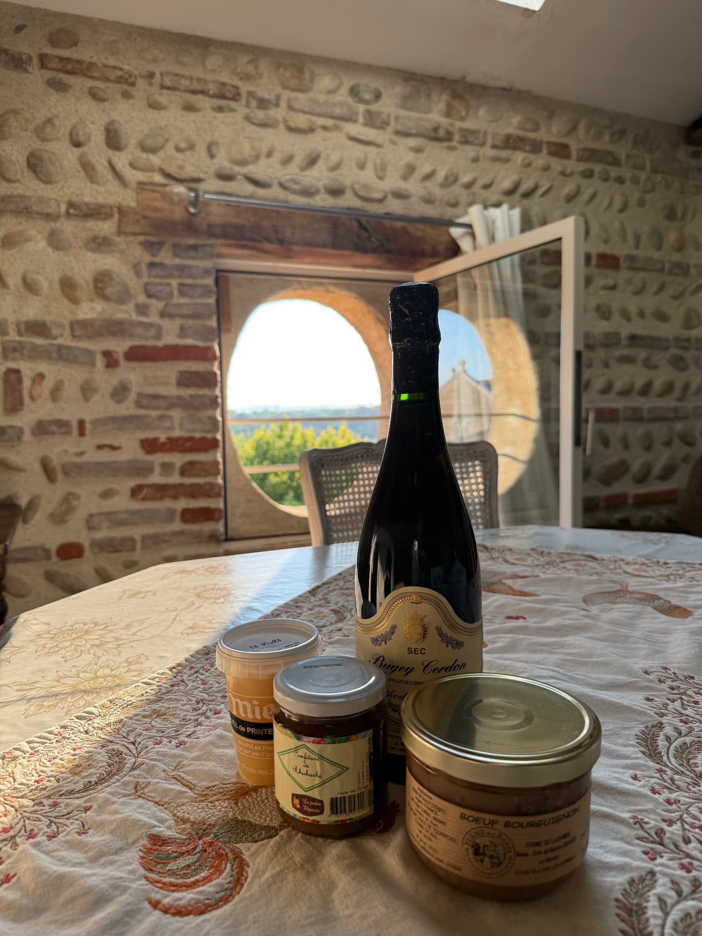 Bugey Cerdon, miel et confitures du terroir posés sur la table d'hôtes