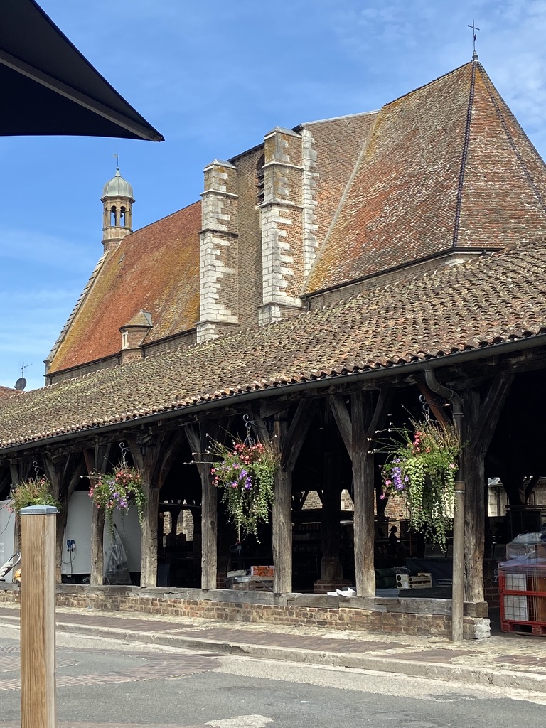 Les piliers de bois et les fleurs suspendues des halles de Châtillon