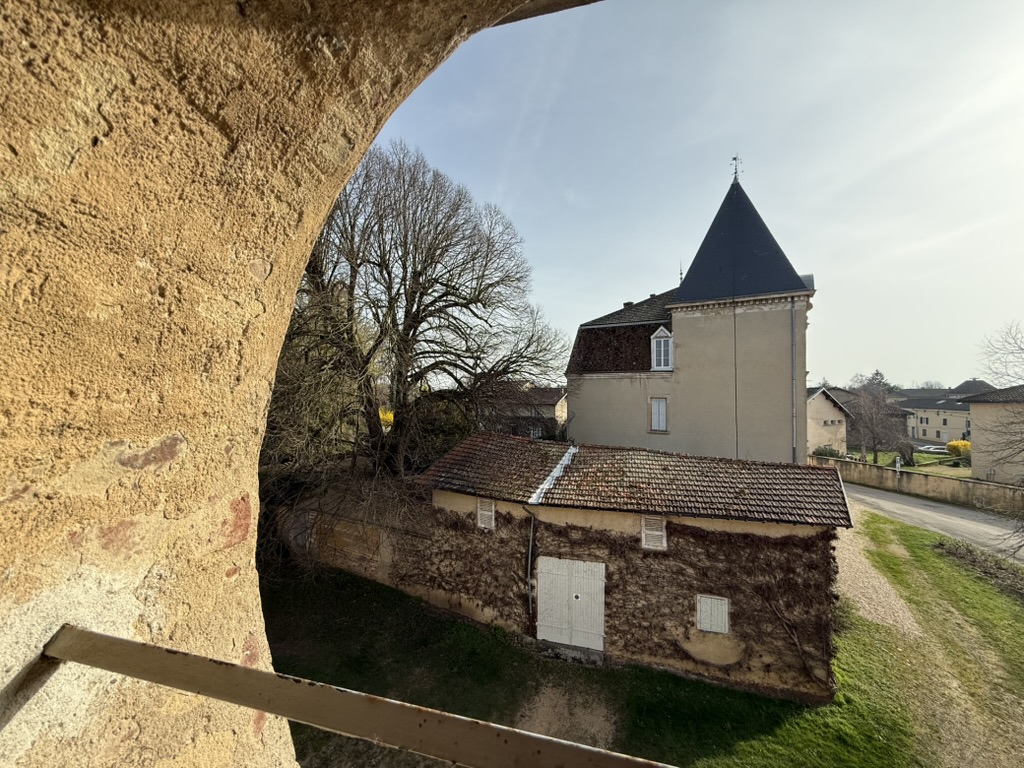 Le château de Neuville-les-Dames vu depuis la fenêtre en plein cintre de la chambre du château