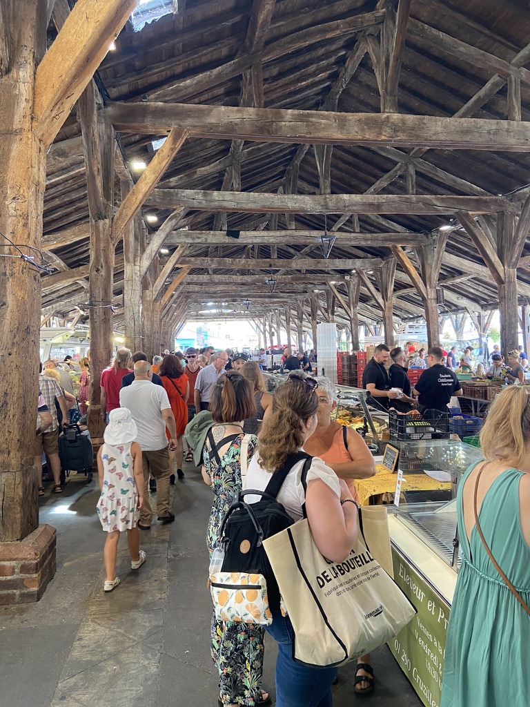 La charpente de chêne des halles du XIIe siècle pendant le marché
