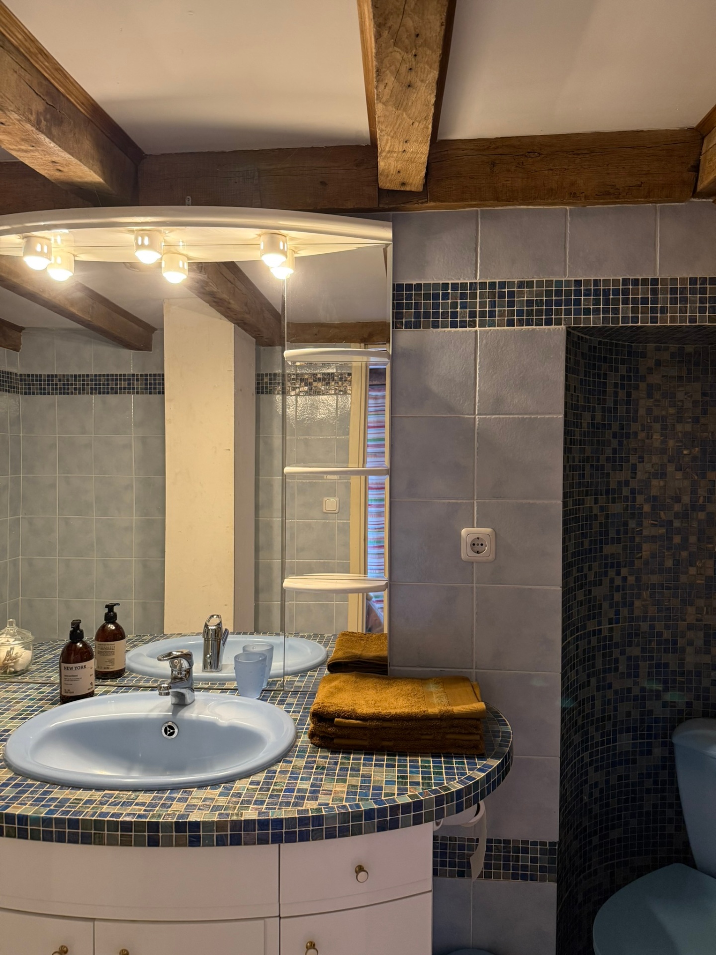 Salle de bain avec baignoire, vasque en mosaïque et poutres anciennes